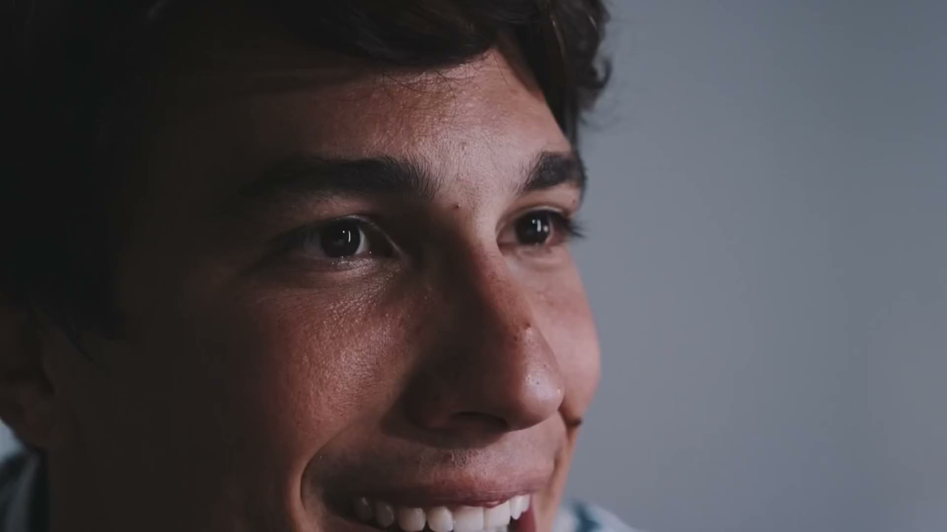 A young man smiles as he talks with his care team